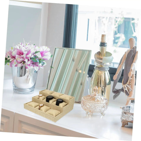 Multi Grid Watch Organizer Tray With Linen Padded Sections displaying two watches on a vanity against decorative items.