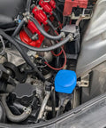Porsche Cayenne Windshield Washer Fluid Cap Replacement 3Q0955455 installed under vehicle hood, with blue reservoir cap