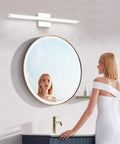 Chrome Bathroom Light Fixtures 24 Inch LED Vanity Bar Over Mirror Lighting IP44 Waterproof 14W 850LM Modern Rectangle Vanity Lamp For Bathroom Acrylic Restroom Sink Light mounted above a round mirror with a woman looking in.
