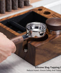 Hand holding a portafilter over the Top Shelf Natural Walnut Espresso Knock Box And Tamp Station, Removable Stainless Steel Grounds Holder.