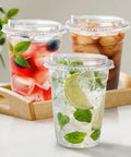 16 Oz Clear Plastic Cups With Lids 50 Pack For Iced Coffee And Cold Drinks Strawless Sip Lids Perfect For Parties Outdoors Office Events Disposable Cups holding iced beverages on tray