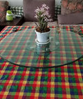Rotating Lazy Susan Turntable with tempered glass on a dining table displaying a potted plant, 360-degree swivel plate visible.