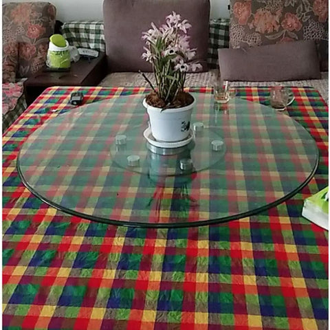 Rotating Lazy Susan Turntable with tempered glass on a dining table displaying a potted plant, 360-degree swivel plate visible.