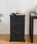 Black Three Drawer Fabric Dresser Tower with Sturdy Metal Frame next to office desk and plant