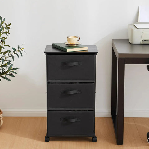 Black Three Drawer Fabric Dresser Tower with Sturdy Metal Frame next to office desk and plant