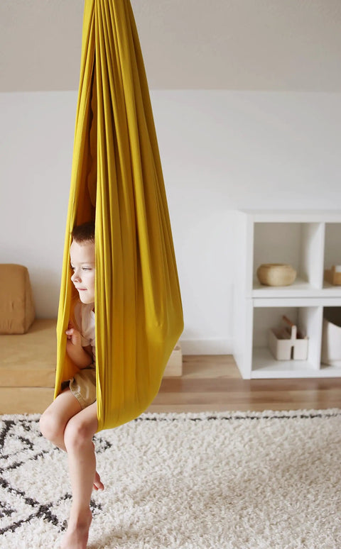 Indoor Outdoor Double Layer Cotton Sensory Swing For Kids With Special Needs Therapy And Vestibular Play Kid Friendly 200 Pound Weight Capacity 360 Degree Swivel Hardware Included Retro Pineapple Design, child in yellow swing indoors