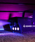 Fog Machine With RGB LED Light and 13 Color Modes, 500W 2000CFM Haze Machine on a carpet, emitting colorful light and fog