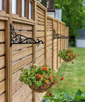 Hanging flower baskets on a wooden fence in a garden
