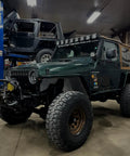 Green off-road vehicle with XLK Series Linkable Mounting Brackets Kit for LED light bars on roof, rugged tires.
