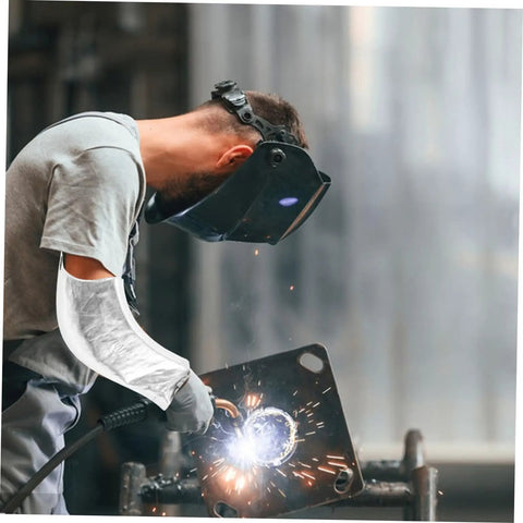 Heavy Duty Aluminum Foil High Heat Resistant Arm Sleeves Sweat Free Adjustable Breathable Guard Shields For Mechanics Hot Shop Work Lab Safety And Backyard Grills worn by a welder, shielding arm from sparks.