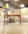Construction worker on scaffold in room with Heavy Duty Carpet Shield Film 36 Inch By 500 Feet 2 Mil Tear Resistant Masking Film