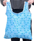 Person holding a blue star-patterned foldable reusable grocery tote bag, lightweight 190T polyester, waterproof, six pack eco-friendly carrier.