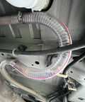Clear 1 Inch High Pressure Hose With Spiral Steel Wire Reinforcement, 10 Ft Long installed under vehicle for fluid transfer.