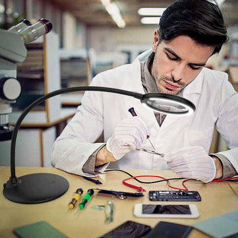 Man using 5X Rechargeable Magnifying Glass With Light And Stand For Reading And Close Work Handy Dimmable LED Desk Magnifier while repairing circuits.