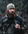 Hunter holding BTH35 V2 Thermal Imaging Handheld Monocular For Hunting And Night Vision, wearing outdoor gear in forest.