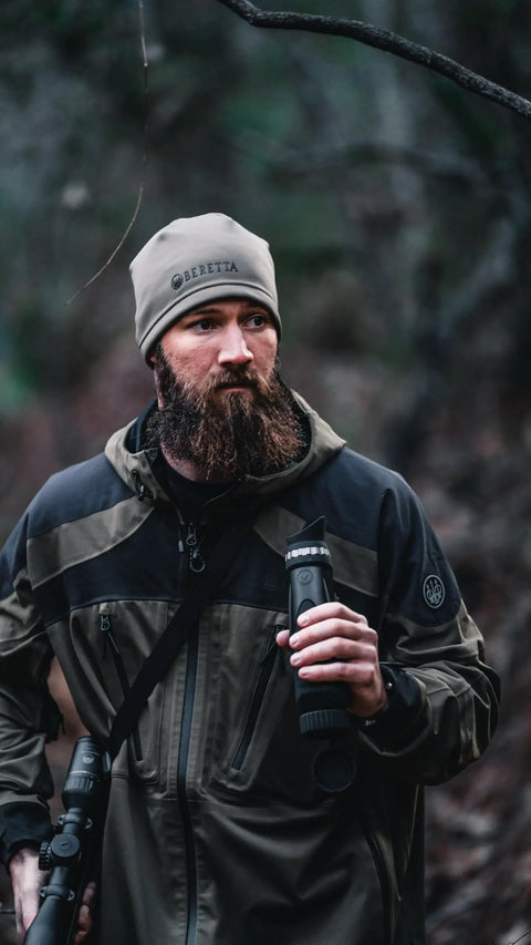 Hunter holding BTH35 V2 Thermal Imaging Handheld Monocular For Hunting And Night Vision, wearing outdoor gear in forest.