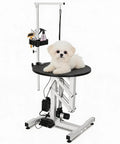 Elevate Your Grooming Game With This Heavy Duty Electric Hydraulic Pet Table Featuring A Rotating Waterproof Top, Remote And Foot Pedal Height Adjustments For Easy Back Saving Lifts Up To 250 Lbs Plus An Overhead Arm Tool Organizer System with dog on top
