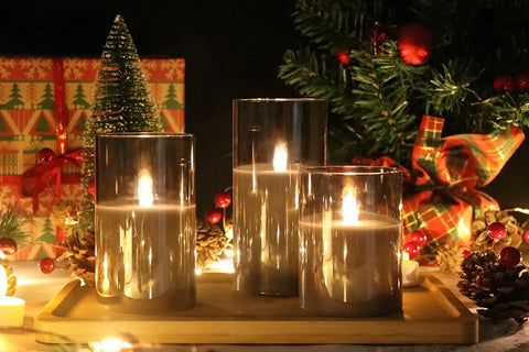 Gray Glass Flameless LED Candles Battery Powered With Timer And 10 Key Remote Real Wax Warm Flicker For Weddings Parties Holidays And Cozy Home Decor Vibes Set Of 3 shown lit amidst festive decorations.