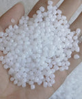 Hand holding 2 lb plastic pellets rock tumbler media protect delicate stones non toxic non static reusable filler in reclosable bags
