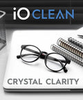 Eyeglass lens cleaner kit, front view: on a laptop with black-framed glasses and notebooks; includes 2 microfiber cloths