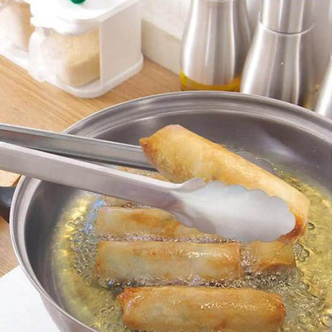 Two Pack 9 Inch And 12 Inch Stainless Steel Kitchen Tongs With Locking Mechanism in use, lifting food from frying pan