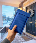 Person holding blue 4x8 bubble mailers 100 pack self seal padded envelopes usable 4x7 inner size on a snowy porch