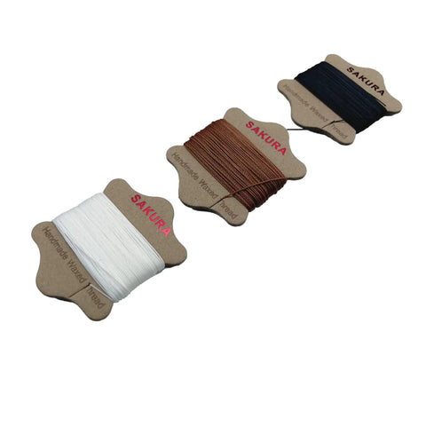 Three spools of waxed thread in white, brown, and black from Upholstery Repair Kit With 0.55mm Waxed Thread And Heavy Duty Needles For Leather Canvas.