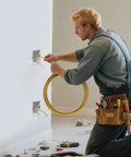 Electrician using Heavy Duty 25ft Fish Tape Wire Puller for Electrical Cables Through Wall Guide with Spring Steel Wire