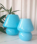 Pair of blue glass lamps with swirl pattern on table, potted plant in background, Swirl Mushroom Glass Lamp In Striped Pink, Hand Blown Translucent Murano Style Table Bedside Light, Italian Modern Decor For Living Room, Dining, Study, Or Baby Nursery, Cozy Home Vibe, Mini Dia 5.1 By 7.1 Inch High