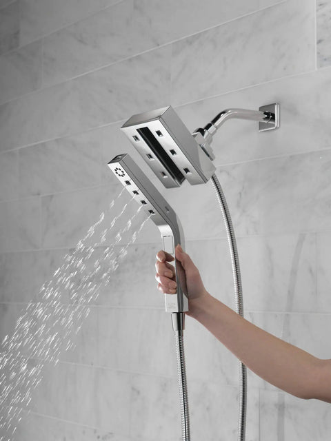 Person using In2ition Four Setting Two In One Shower Combo with H2Okinetic Technology dual shower heads in black stainless finish.