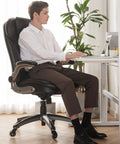 Man working at desk in Ergonomic Executive Office Chair For Home And Desk, High Back Leather Swivel Chair With Padded Flip Up Armrests