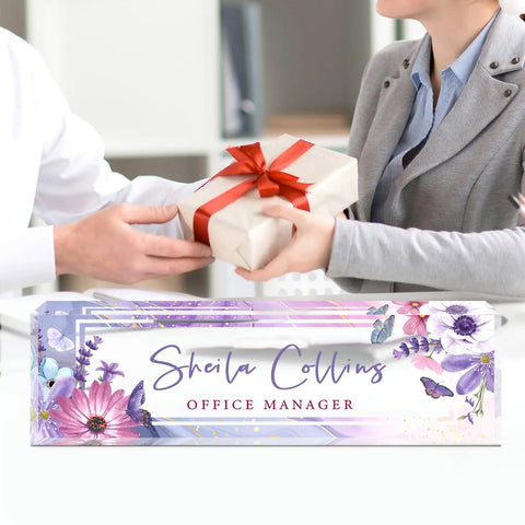 Personalized Acrylic Desk Name Plate With Purple Flower Design on office desk with gift exchange.