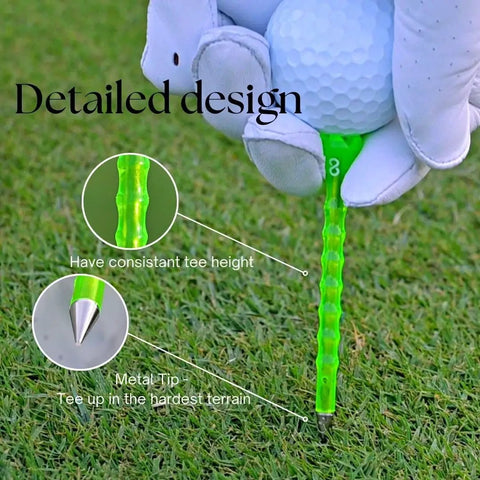 Close-up of Forever Tee Premium Metal Unbreakable Golf Tee with green plastic wrap and extended metal tip, held by gloved hand on grass.