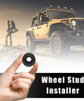 Close-up of a hand holding Wheel Stud Installer Tool for Cars and Light Duty Trucks with an off-road vehicle in the background.