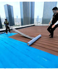 Two workers applying Heavy Duty Self Adhesive Asphalt Roofing Tape With Thick Aluminum Foil on a flat roof surface.