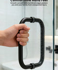 Hand gripping 8 Inch Center-To-Center Shower Door Handle 304 Stainless Steel Back-To-Back Glass Pull for Frameless Sliding Bathrooms in matte black.