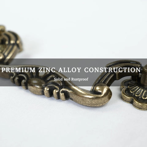 Close-up of antique brass drop bail pull showing vintage floral design and zinc alloy material, part of Six Pack Antique Brass Drop Bail Pulls With Vintage Floral Base Plates For Cabinets Dressers And Wardrobes And Cupboards 3 Inch Hole Centers 76mm Classic Decorative Hardware For Furniture Renovation.