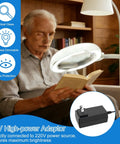 Man reading a book with Eight Times Magnification Floor Magnifying Glass With Light And Stand, 56 LEDs Gooseneck Floor Lamp.