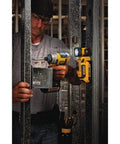 Worker using power tools with 20V Max LED Work Light Rechargeable Magnetic Clip On Freestanding Light With 360 Degree Pivot Head Hands Free Utility Light For Job Sites And DIY Projects attached to metal framework.
