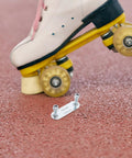 Four Piece Roller Skate Repair Parts Kit With Five Metal Plates And Mounting Hardware For Recreational Quad Skating Shock Cushion Set 20mm Fits Most Setups For All Skill Levels shown with skate on pavement.