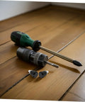 Healifty 4pcs Heavy Duty Metal Spring Pins With Universal Compatibility next to a green and black screwdriver on wooden floor.