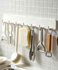 Premium Heavy Duty Self Adhesive Coat Rack Wall Mount Featuring Seven Robust Hooks, organized kitchen utensils on wall.