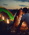 Outdoor Halloween Lights Four Pack LED Torch Lanterns With Flickering Flame Effect Waterproof Tiki Torches For Lawn And Garden Decoration Boss Bonfire Vibe Without Real Fire Warm White installed near tent in night setting