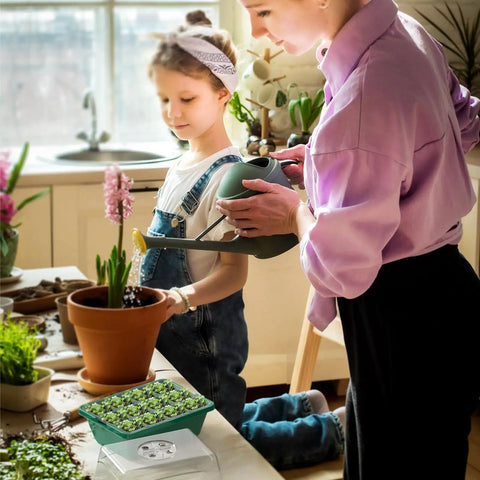 Woman and child gardening indoors with Seed Starter Tray Kit 10 Pack With Heightened Lids For Seed Starting, green tray visible.