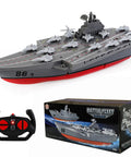 Remote Controlled Warship Battleship And Aircraft Carrier RC Boat With 4WD Dual Motors And 2.4G Radio Speeds Up To 10 Kmh Great For Lakes And Pools Ideal For Exhibits Or Military Model Collectors Beginner Friendly For Ages 14 And Up. Showcasing model with box and remote control.