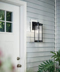 Lit 16 Inch Outdoor Wall Light 1 Light Sconce with Clear Ribbed Glass in Black Finish beside white door