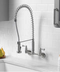 Dual Handle Pro Grade Commercial Style Wall Mount Kitchen Faucet With Pull Down Nozzle And Dual Spray Options In Stainless Steel 1.8 GPM Water Saver For Heavy Duty Kitchens Perfect For Busy Kitchens And Home Chefs installed on white tile wall.