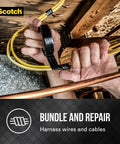 Hands using 3/4 Inch Vinyl Electrical Tape For Splices And Wire Repairs, 66 Feet Long, 7 Mil Thick, Indoor Outdoor Use, High Adhesion Insulation Up To 600V, Protective Jacket For Primary Insulation And High Voltage Cable Repairs to bundle yellow wires against wooden beam.
