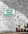 Industrial Aluminum Safety Sign For Lockout Tagout 8x12 Inches mounted on white brick wall near bottles