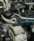 Close-up of Pry Bar Wrench Adaptor 3/8 Inch Double Square Drive 8 Point with SCM440 steel wrench in automotive setting.